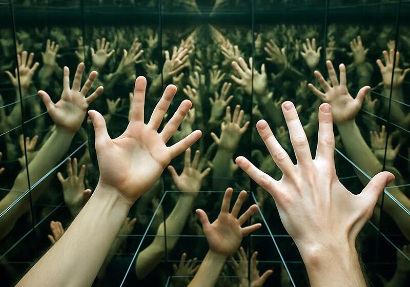 Pair of hands multiplied in hall of mirrors