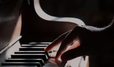 Hand playing piano keys