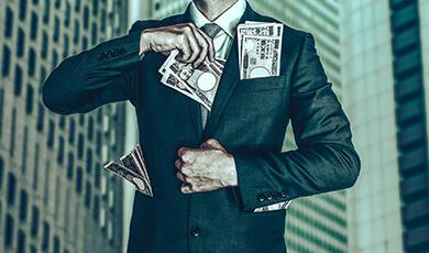 Buisness man stuffing money into suit jacket