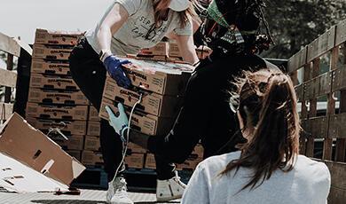 Person giving crate to woman