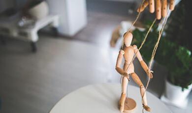 Image of wooden doll on strings