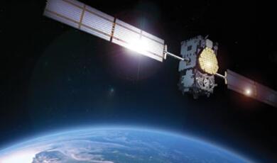 Satellite orbiting Earth with a bright light emanating from it