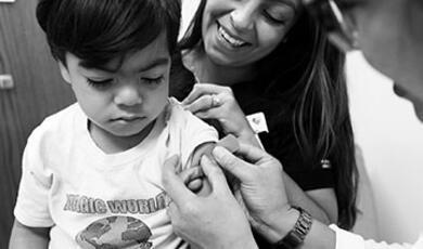 Black and white photograph of little boy getting vaccinated