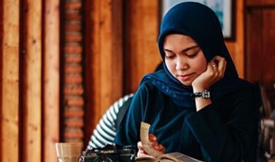 woman in headscarf reading