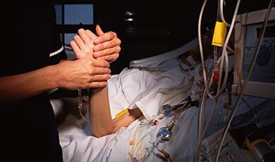 a nurse holding the hand of a patient in hospital