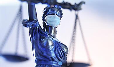 lady justice statue wearing a covid mask