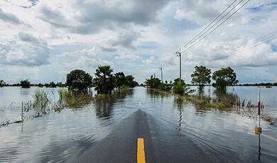 Tarmac road disappearing into flood waters