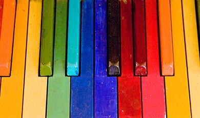 piano keys painted in the colours of the rainbow