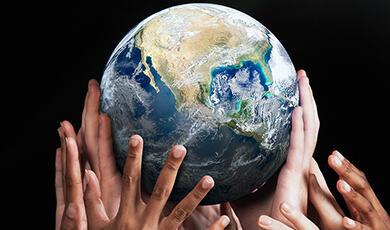 lots of human hands holding the earth