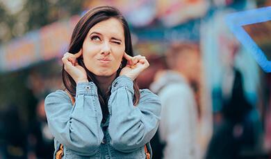 a woman sticking her fingers in her ears