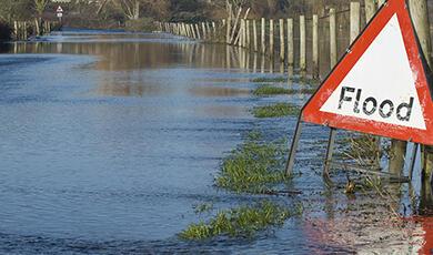 a sign reading Flood next to a body of water