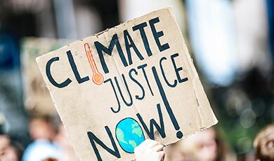 A placard reading 'Climate Justice Now!'