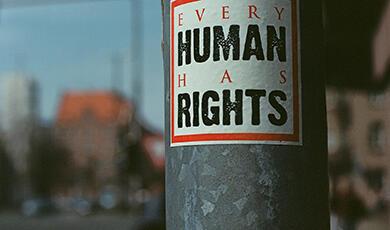 Sticker on lamppost that reads Every Human has Rights