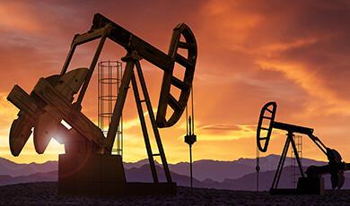 Oil field machinery,  silhouetted against sunset