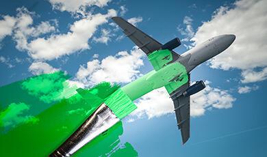Aeroplane with green wash over its trail of fumes