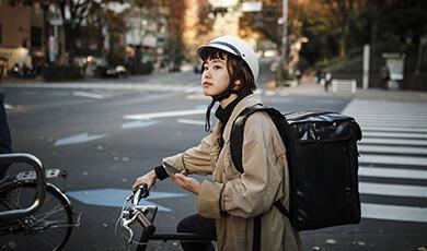 a woman on a bike making a delivery