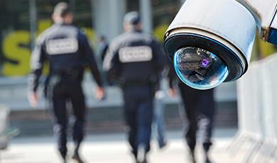 a CCTV camera with police officers in the background