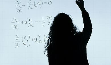 Silhouette of a person writing mathematical equations on a whiteboard
