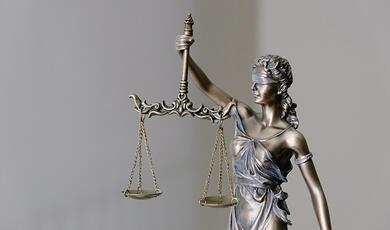 Small statuette of Justice blindfolded with scales held aloft
