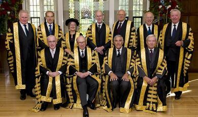 The justices of the supreme court in black and gold robes