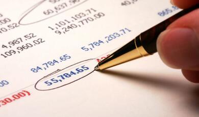 a pen pointing to the figure '55,784.65' on a spreadsheet